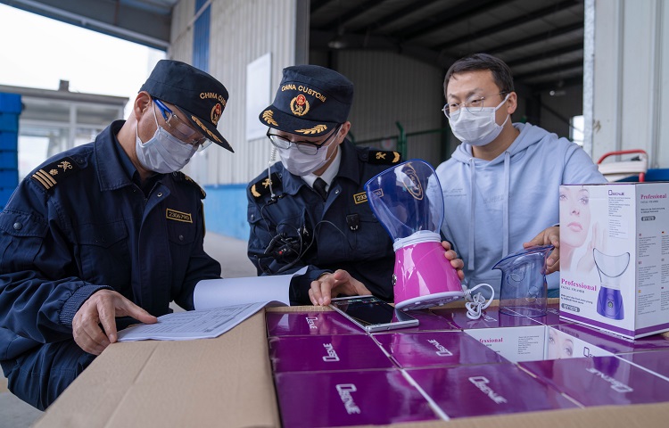 图为：南通海关工作人员对市场采购贸易出口货物实施查验20200316+杨阳摄3