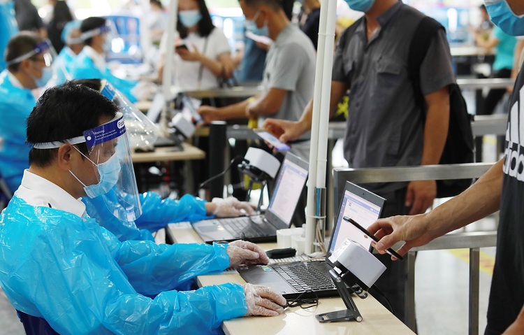 图为：关员对过关旅客健康申报资料进行验核+俞波摄