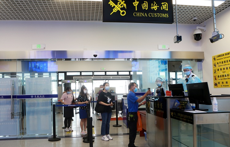 图为：旅客排队向关员进行健康申报+俞波摄