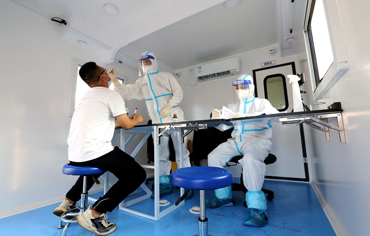 图为：海关关员在方舱对下船船员实施鼻咽试子采样+宋歌摄