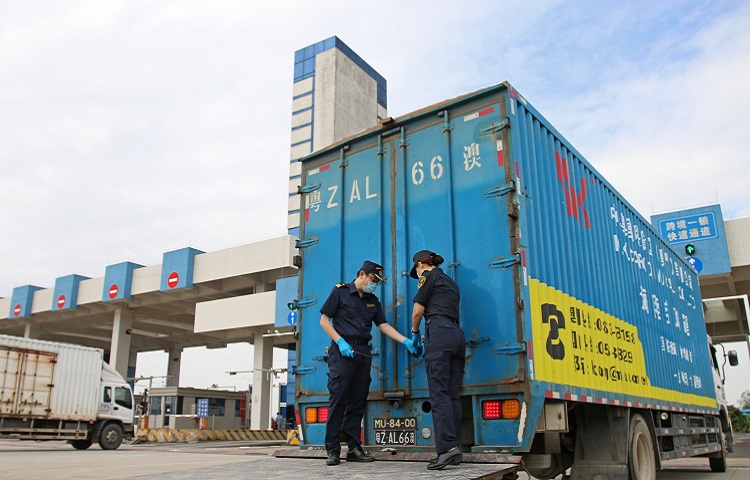 图为：海关关员检查“跨境一锁”电子关锁工作情况+何雪雁摄