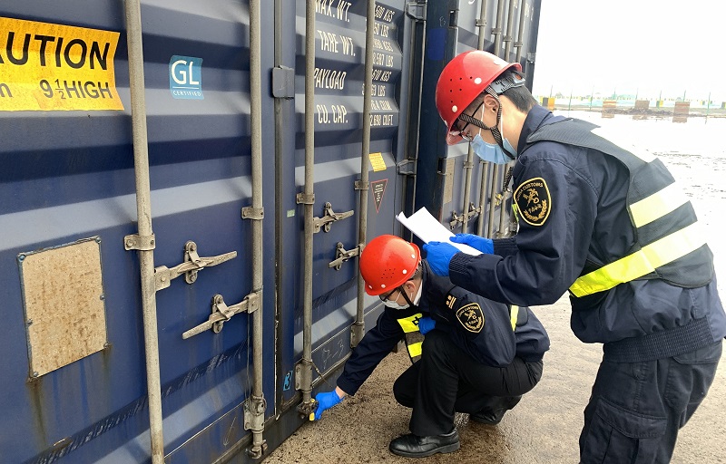 图为：海关关员对出口内支线集装箱实施现场验封+秦玉川摄