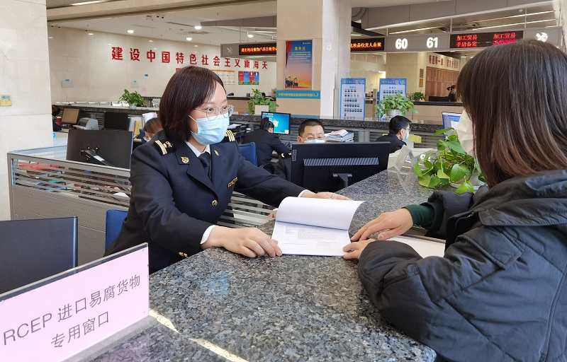图为：海关关员在RCEP进口易腐货物专用窗口为企业办理通关业务+郑军摄