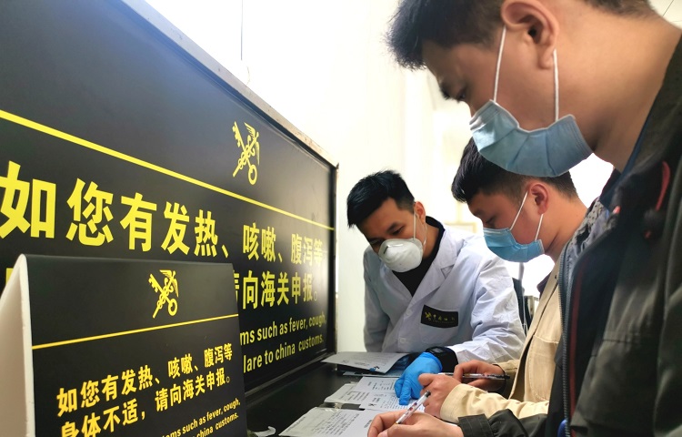广州海关所属南沙海关关员在船员通道知道拟登轮工作的船员进行健康申明卡填报——殷寿柏摄