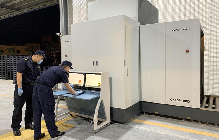 图为海关查验人员正在使用货物X光机对进口的葡萄酒和塑料辅助实施人工查验 图为海关查验人员正在使用货物X光机对进口的葡萄酒和塑料辅助实施人工查验