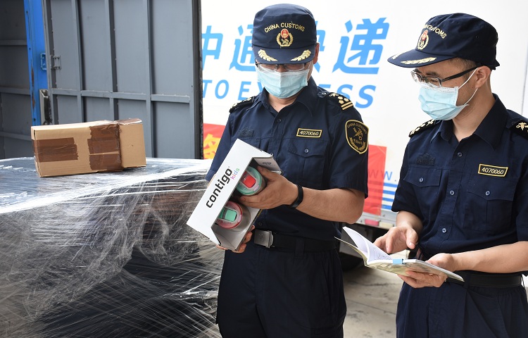 1.龙南海关关员在龙南保税物流中心对首票跨境电商网购保税进口货物进行监管-唐银摄