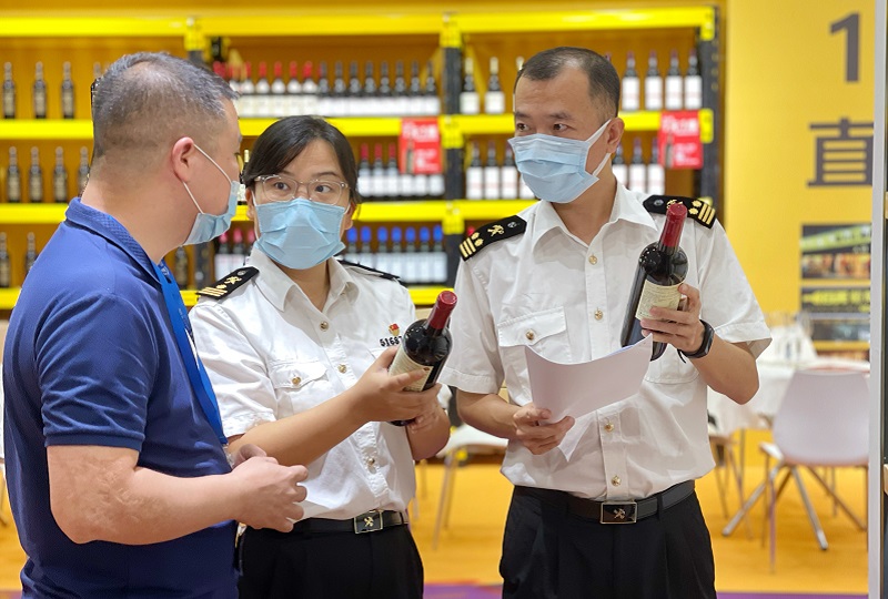 7月30日，广州海关所属广州会展中心海关关员在第26届中国（广州）国际名酒展展会现场向参展商讲解酒类进口通关中标签注意事项。