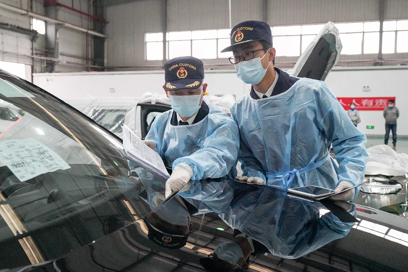 图为：关员对进口汽车开展检验监管