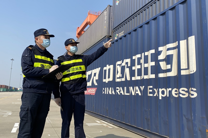 图为：关员在现场监管中欧班列货物