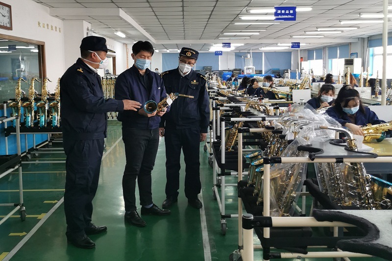 關員在樂器生產企業進行現場監管