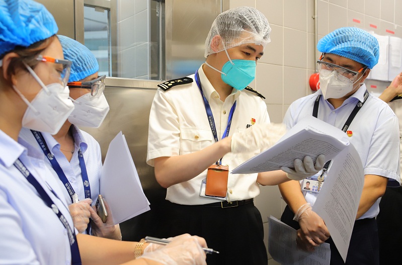 图为：大兴机场海关关员在对食品生产经营企业监管时开展嵌入式普法宣传。王志伟摄