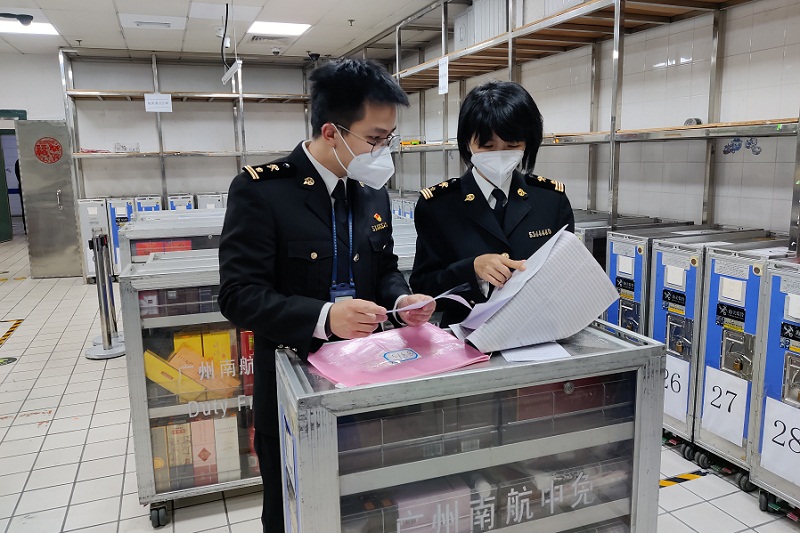 广州海关所属广州白云机场海关关员查看机上免税小车装配情况。[1]
