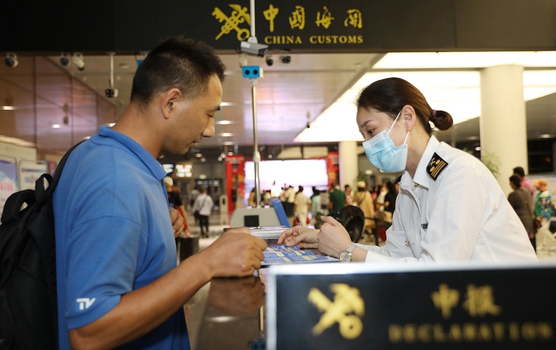 圖為：關(guān)員為旅客提供通關(guān)咨詢服務(wù)+俞波攝