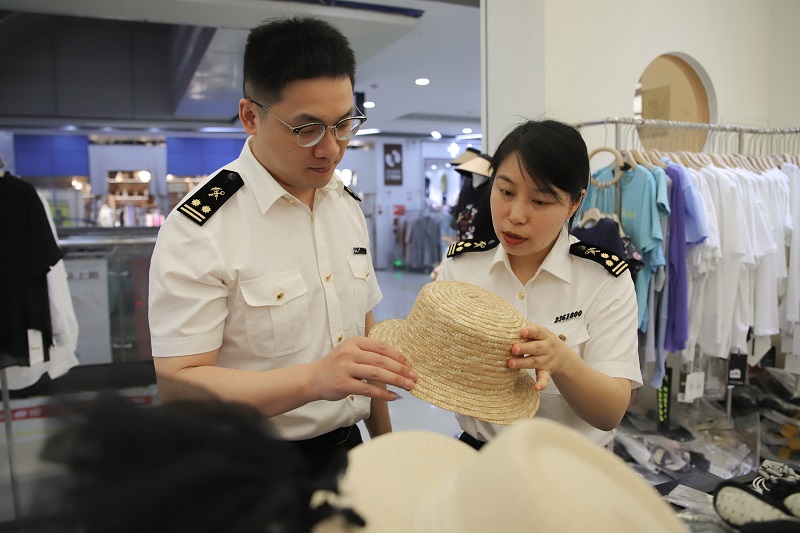 图为：常熟海关关员在市场采购商家了解出口情况。陆焰摄