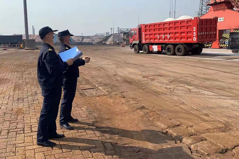 图为：湛江海关所属霞山海关关员在码头监卸进口钾肥